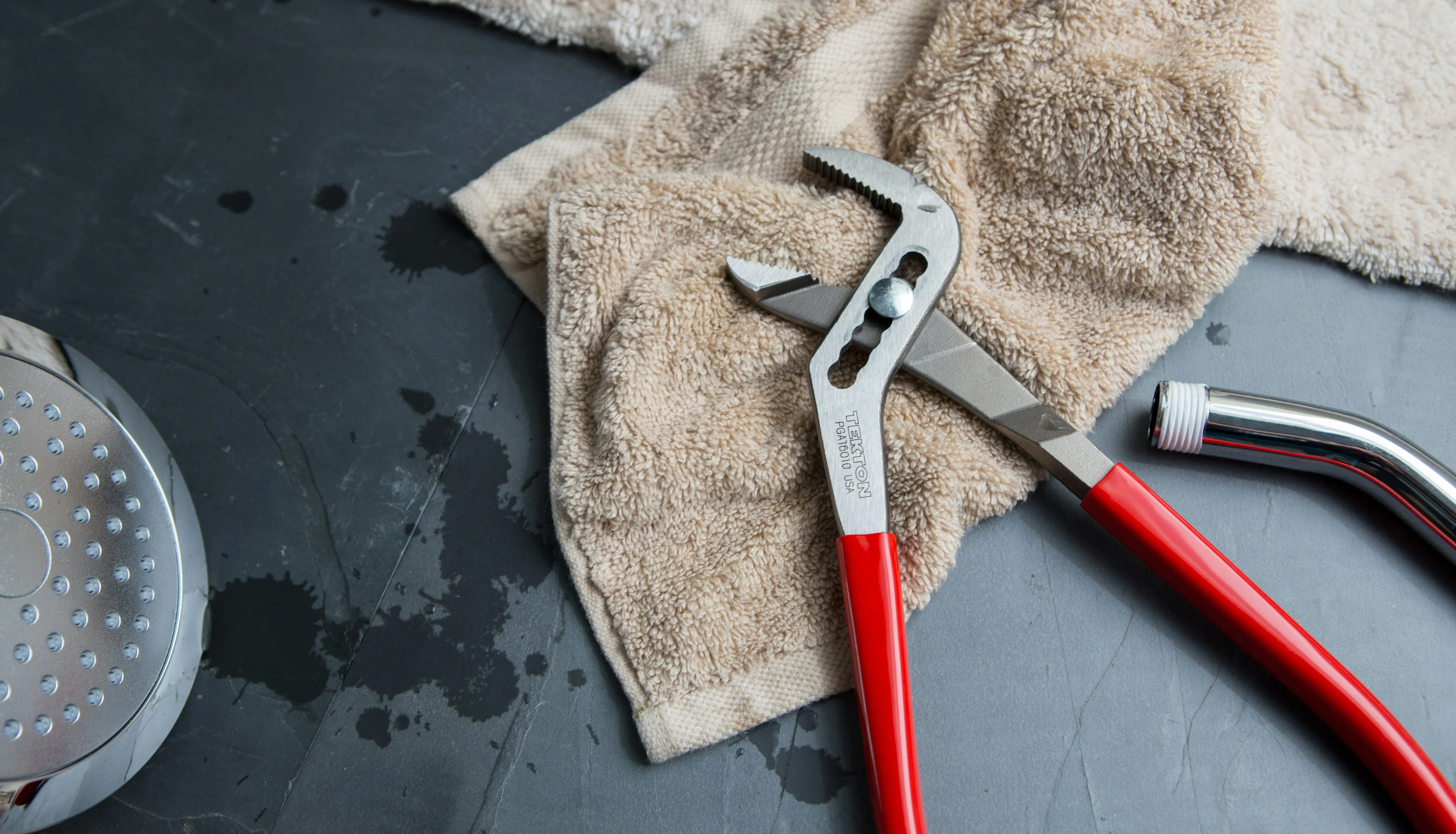 Pince et pommeau de douche posés lors d’une réparation de plomberie