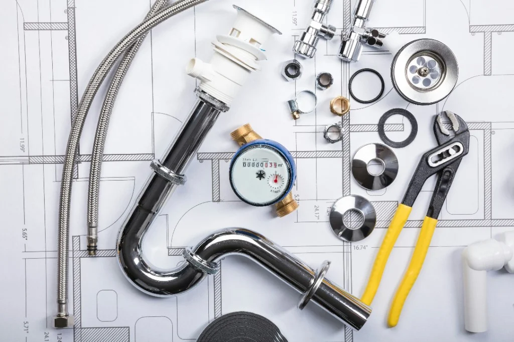 Plumbing tools and blueprint on a job site