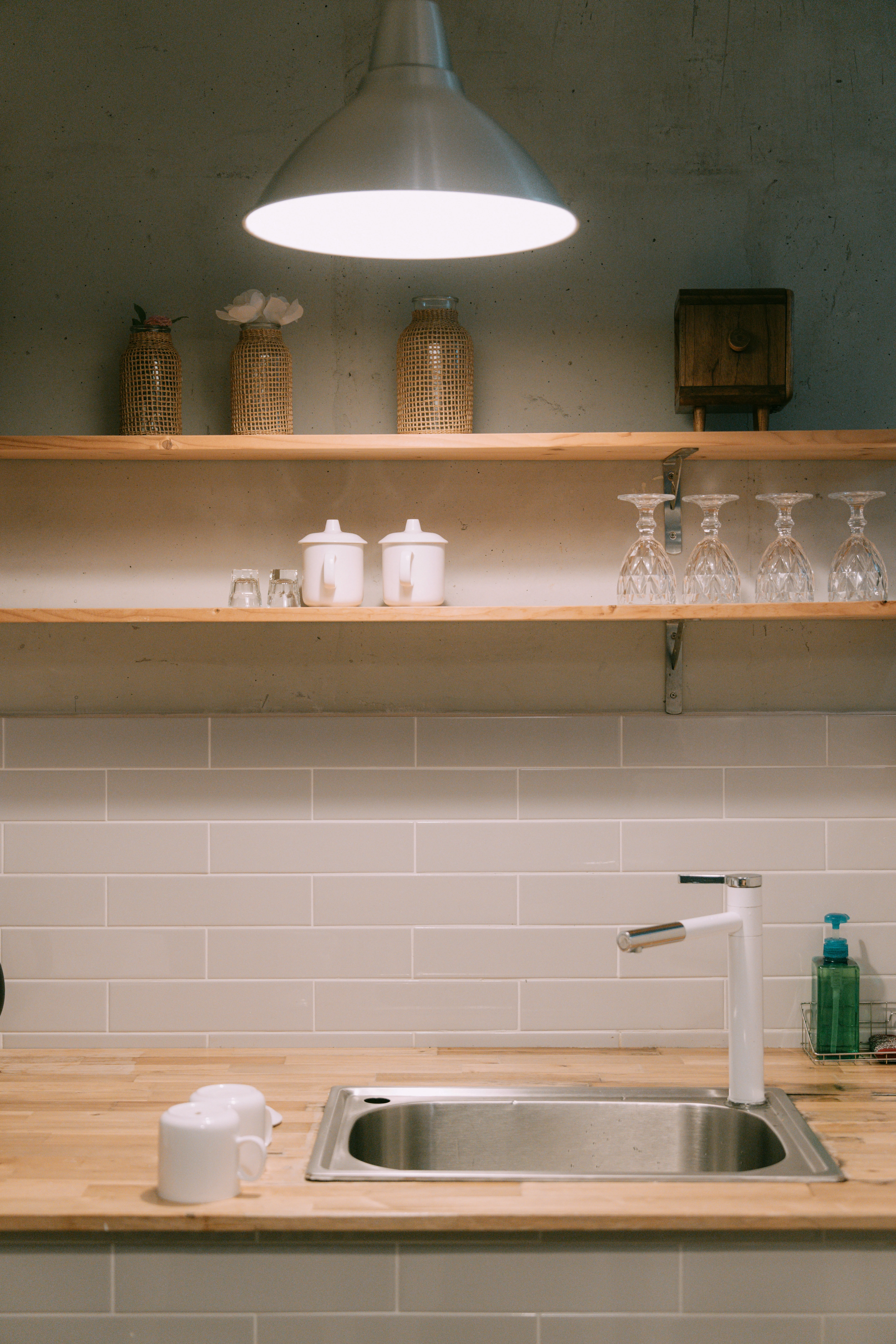 Stainless steel kitchen sink with a designer white faucet on a wood countertop
