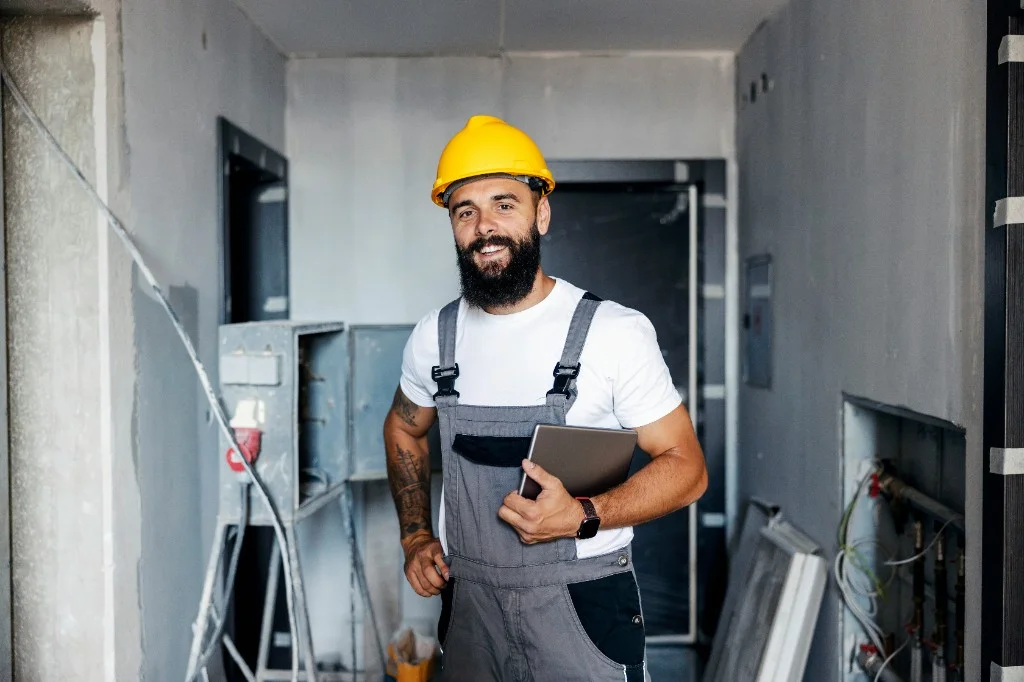 Plombier professionnel avec casque et tablette sur chantier