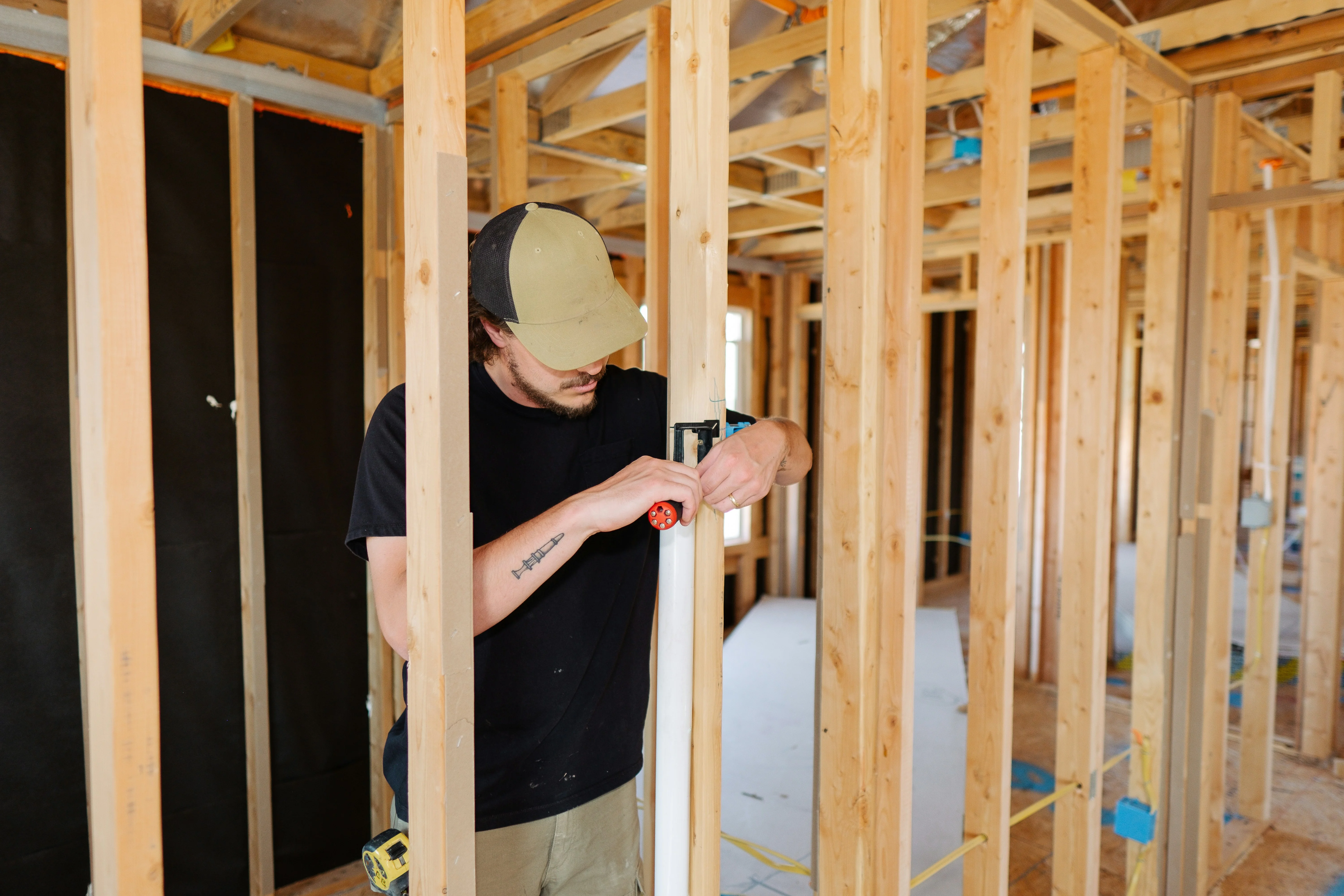 Plumber installing PVC pipe in a house under construction